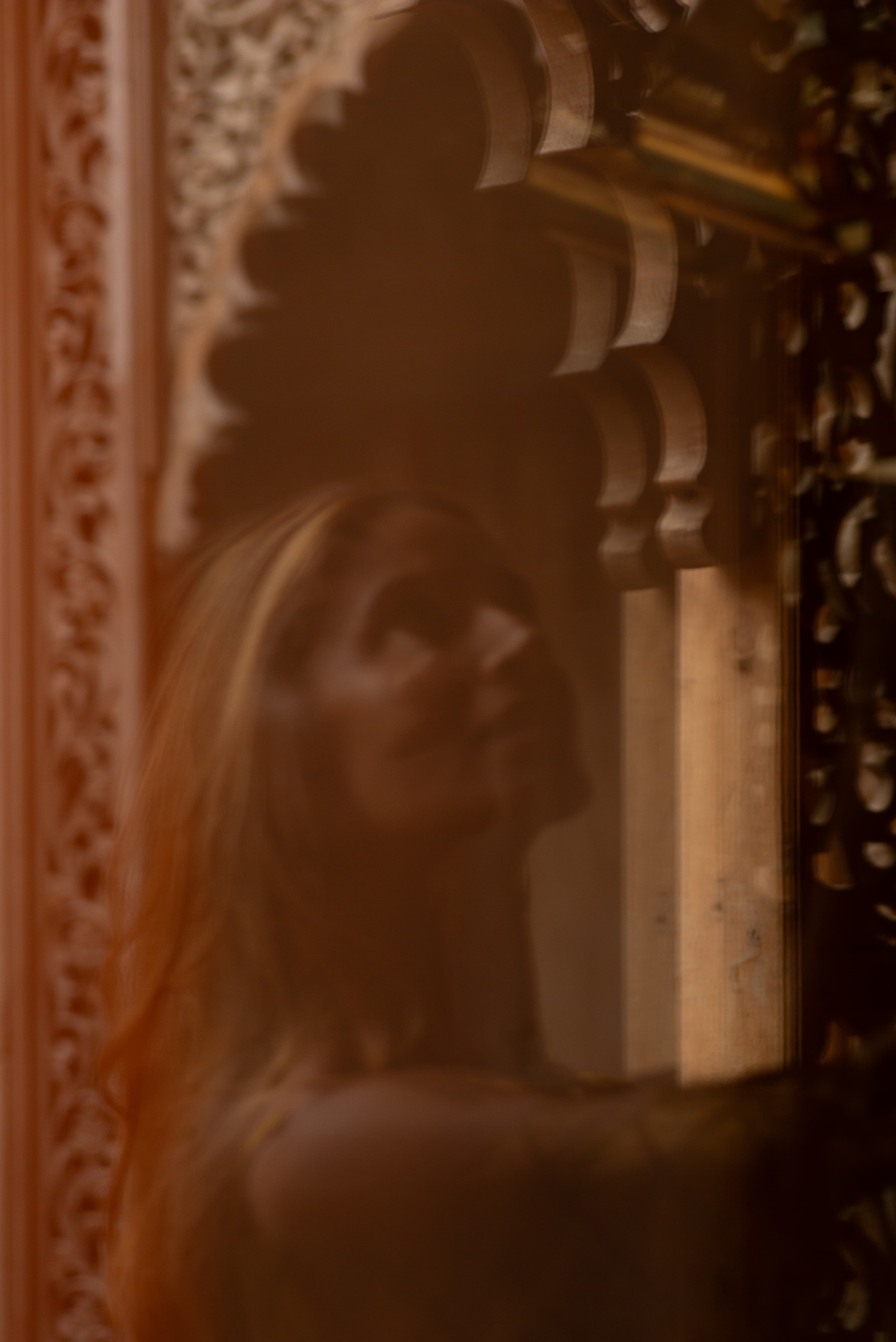 Ruby Noir reflected in an ornate mirror